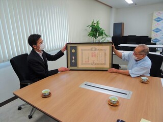 写真　市長と受章者と勲記